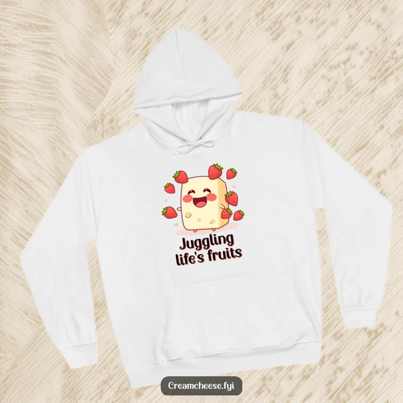Funny cream cheese block grinning while juggling strawberries, depicted on a cozy hoodie. A whimsical and funny fruit illustration, perfect as a funny gift.